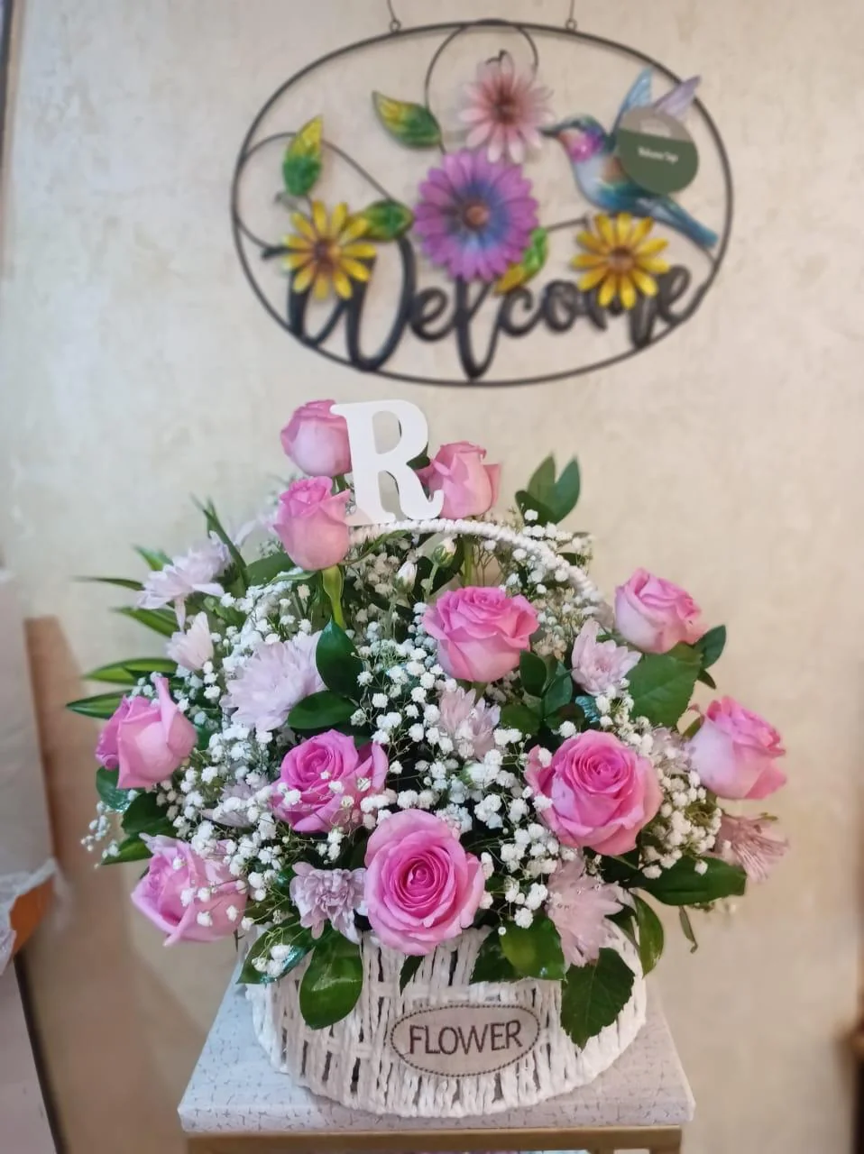 Pink rose basket with white filler flowers and a personalized initial letter