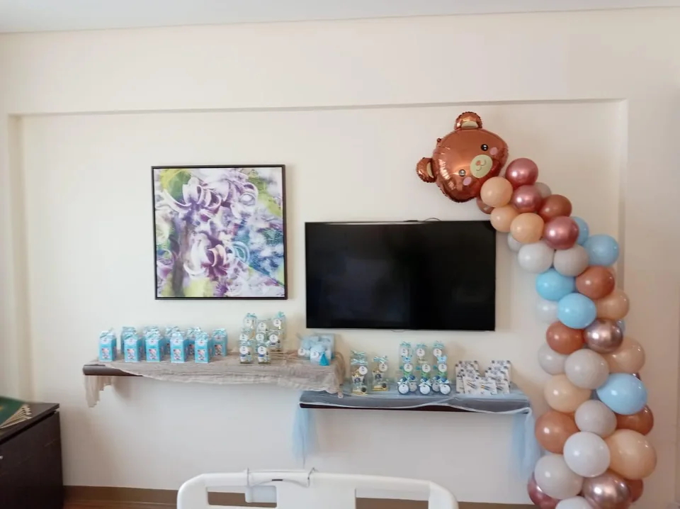 Baby-boy room decoration with a blue and neutral balloon garland and gift table