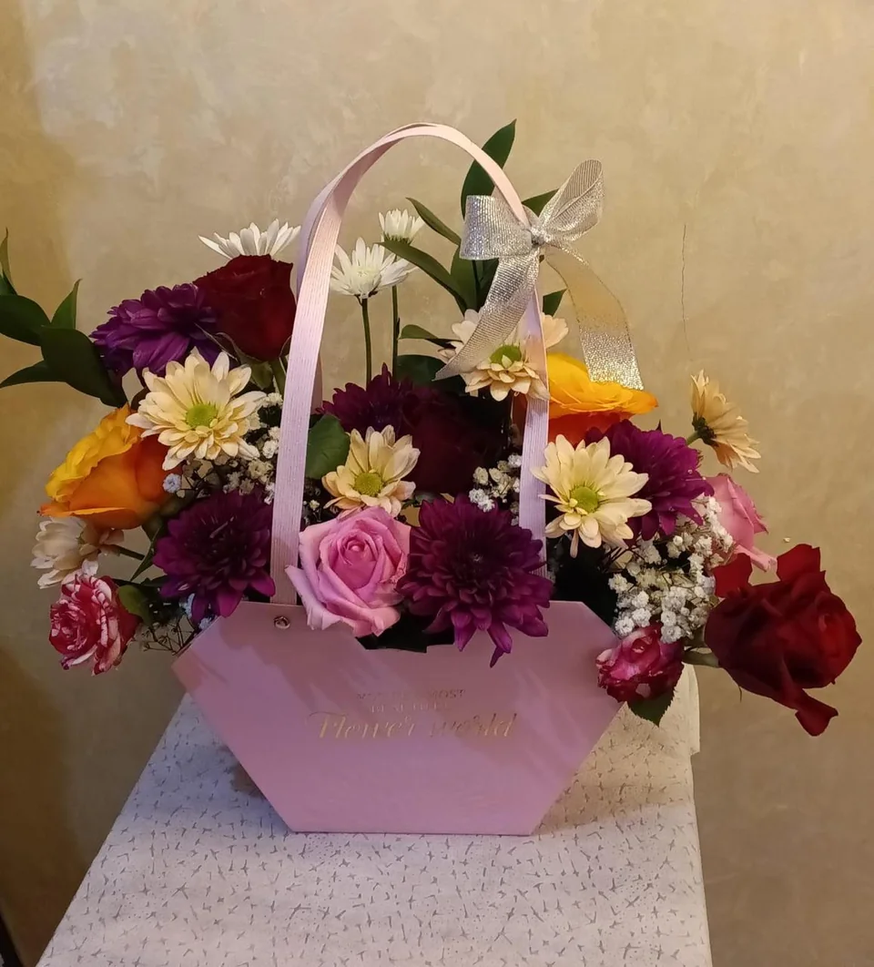 Large pink flower bag filled with orange, purple, red and white blooms