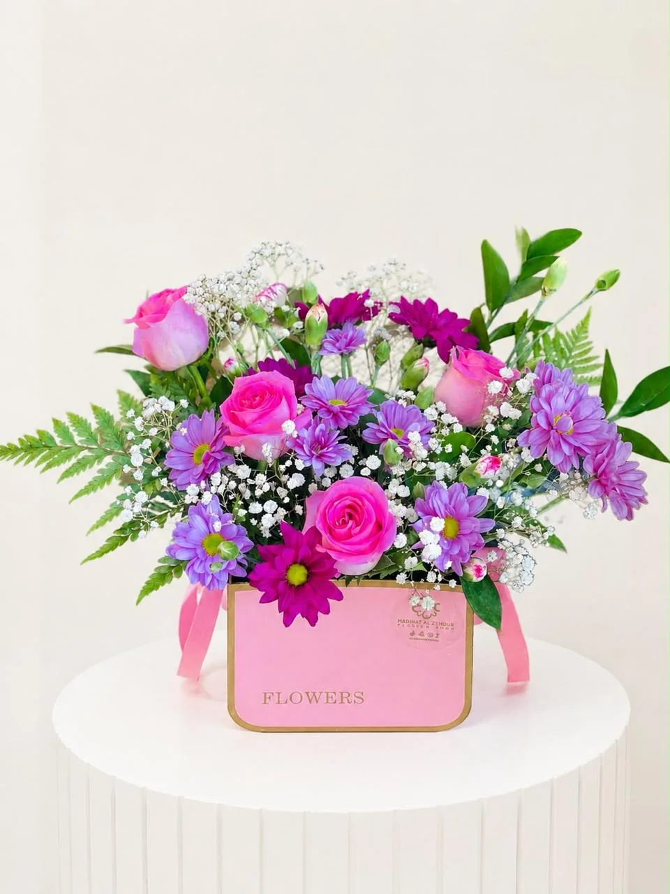 Soft pink square flower box with pink roses, purple blooms and white filler flowers