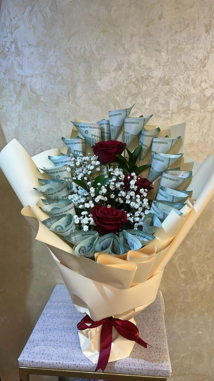 Cash and rose bouquet with rolled banknotes, red roses and white filler flowers