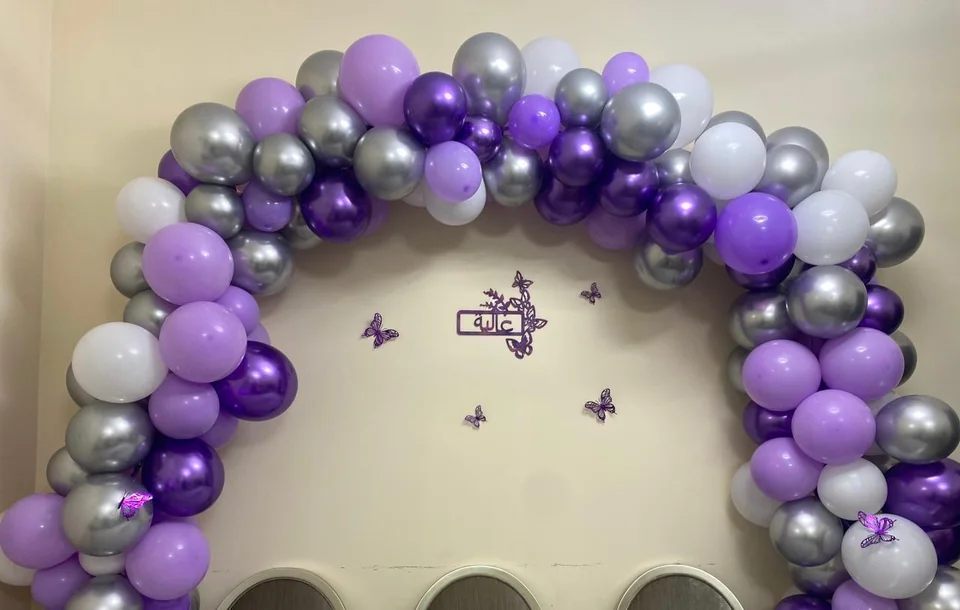 Personalized purple, silver and white balloon arch with a custom name and butterflies