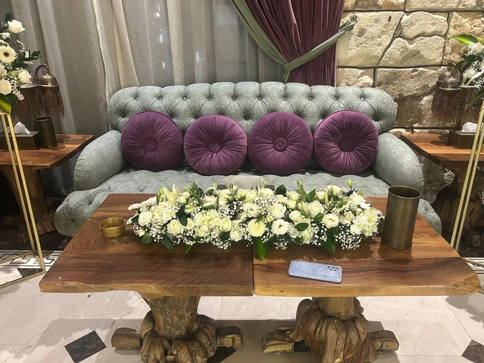 Formal engagement seating setup with a long white floral table arrangement and matching side displays