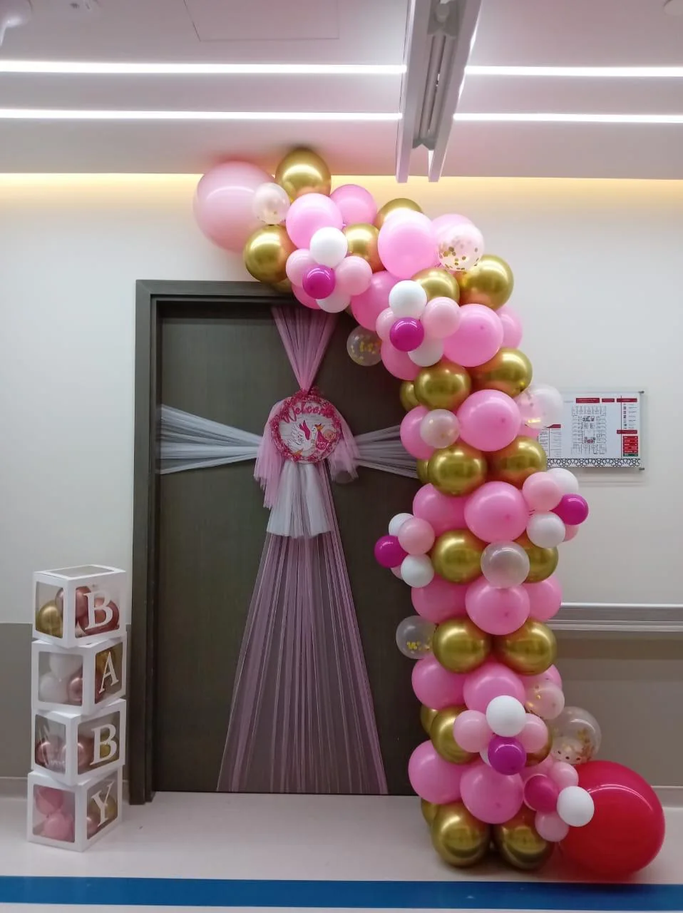 Full hospital-room newborn decoration with pink, white and gold balloons and baby blocks