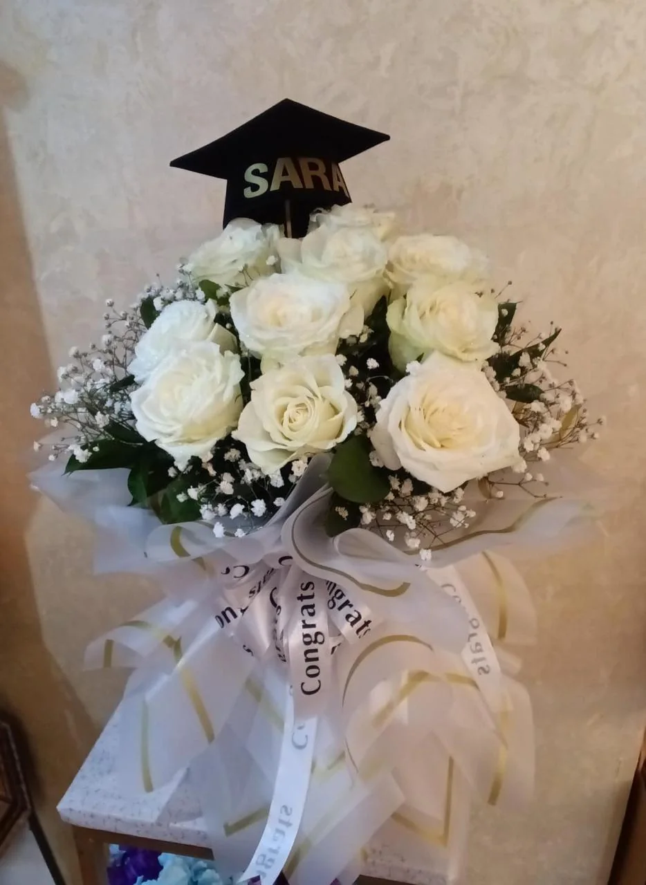 White rose graduation bouquet with a personalized black cap topper