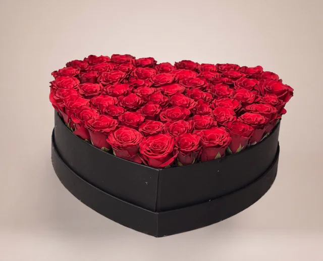 Black heart-shaped flower box filled with red roses