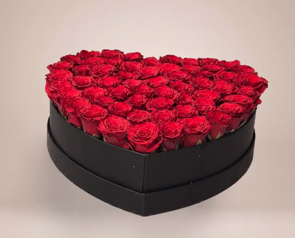 Black heart-shaped flower box filled with red roses