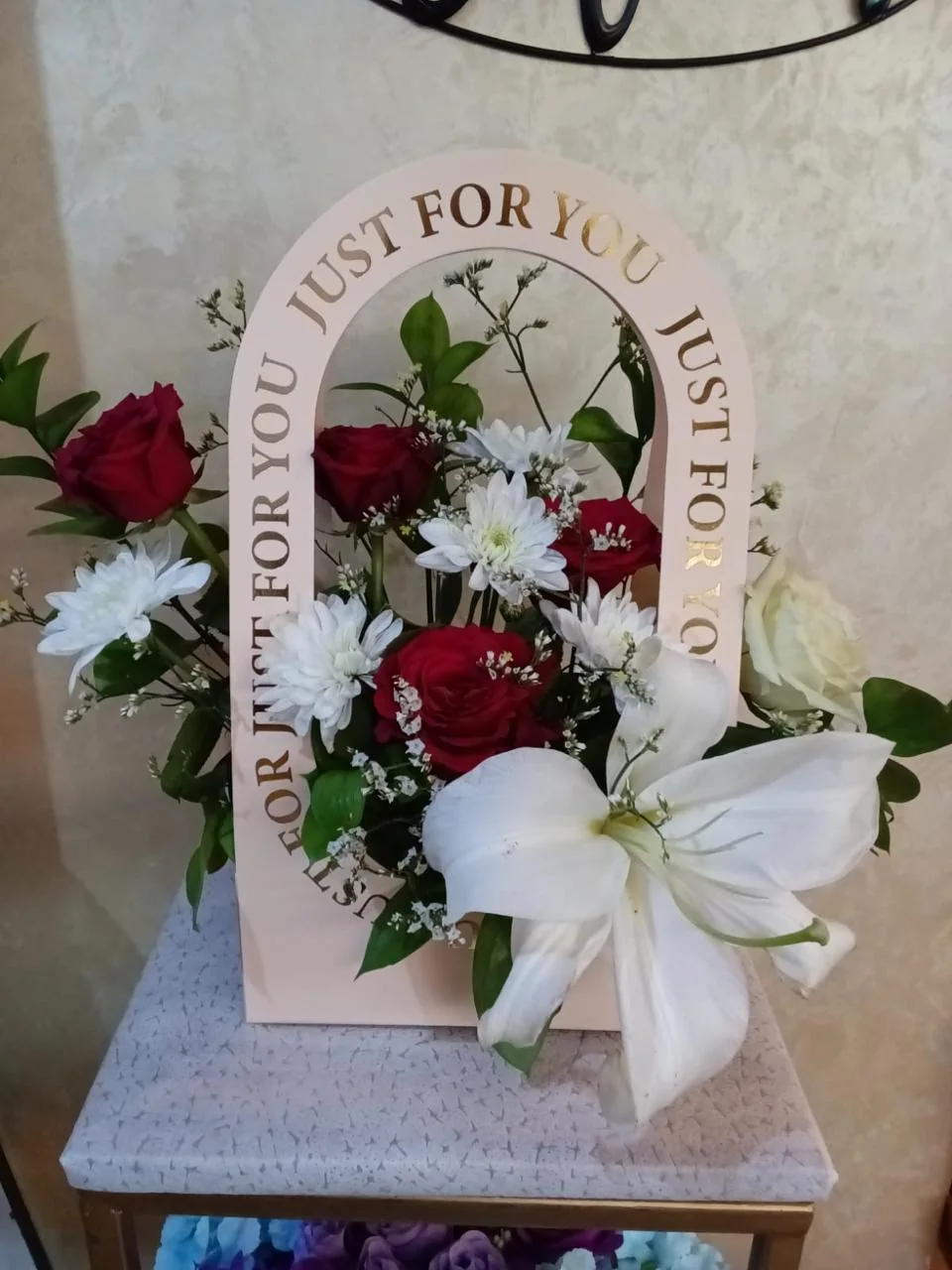 Pink romantic flower box with red and white blooms and a Just For You arch