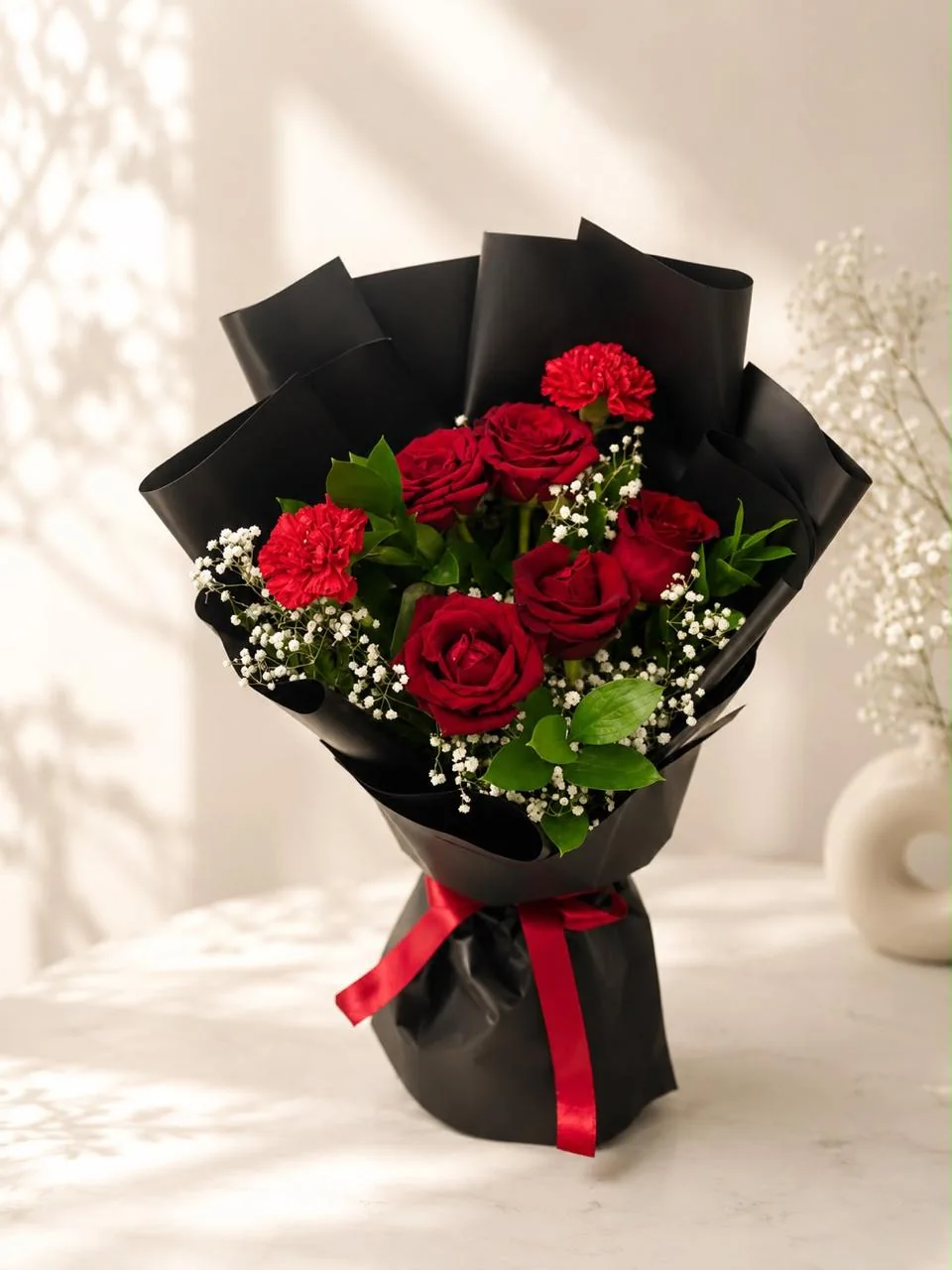 Midnight romance bouquet with red roses and carnations in black wrapping
