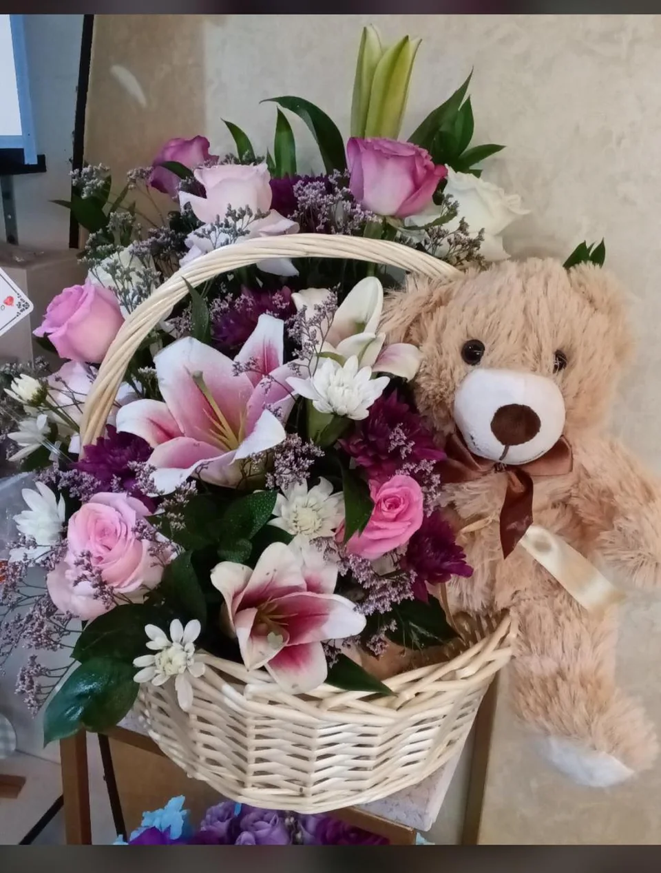 Newborn girl gift basket with pink and white flowers and a teddy bear