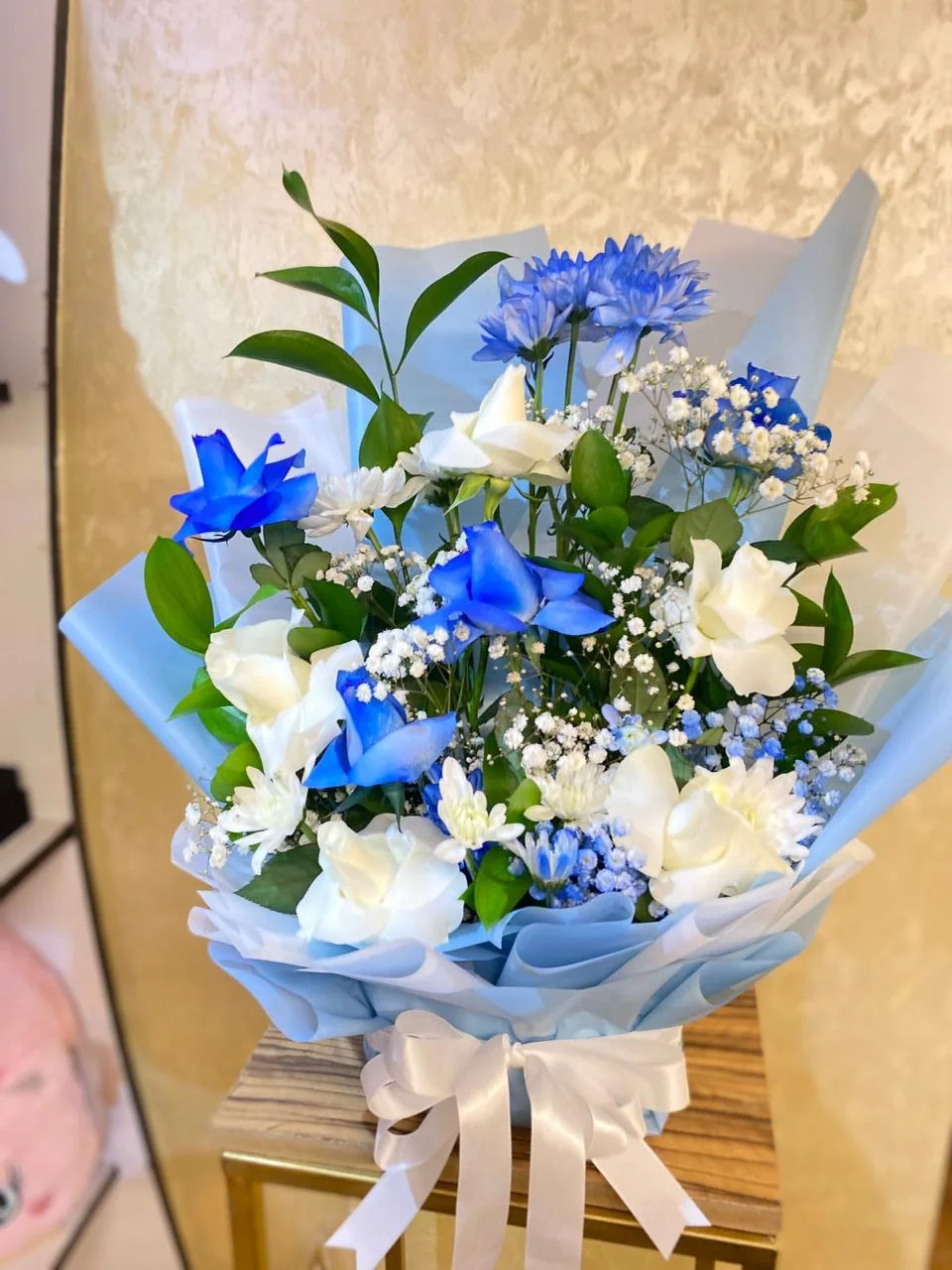 Blue and white flower bouquet with roses, daisies and pale-blue wrapping