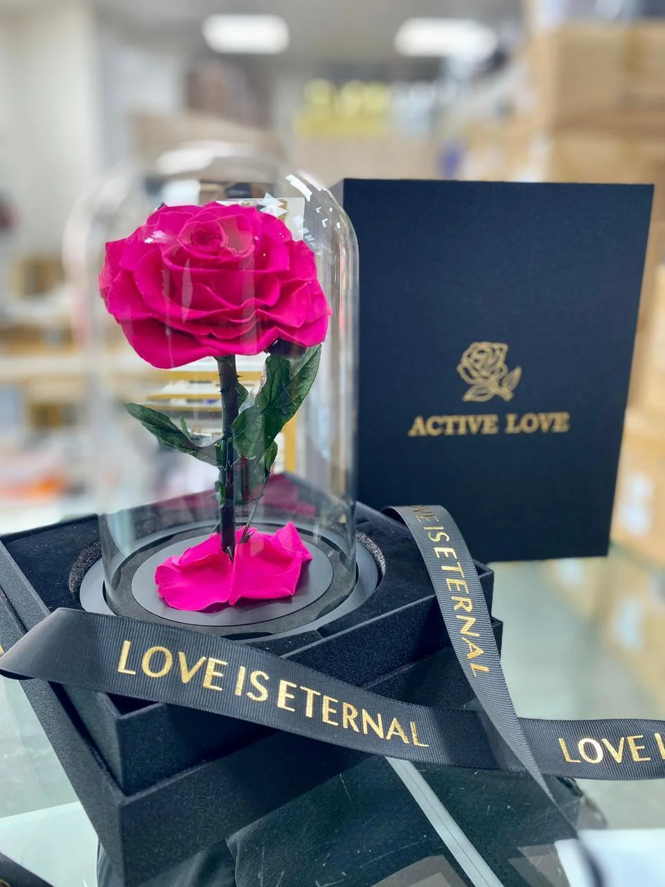 Pink infinite rose under a clear dome with Love Is Eternal ribbon