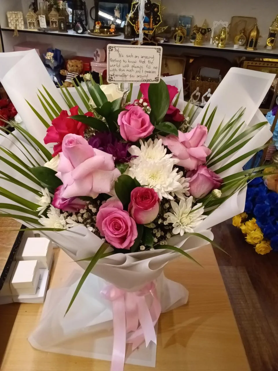 Soft mixed bouquet with pink, white and burgundy flowers in pale wrapping