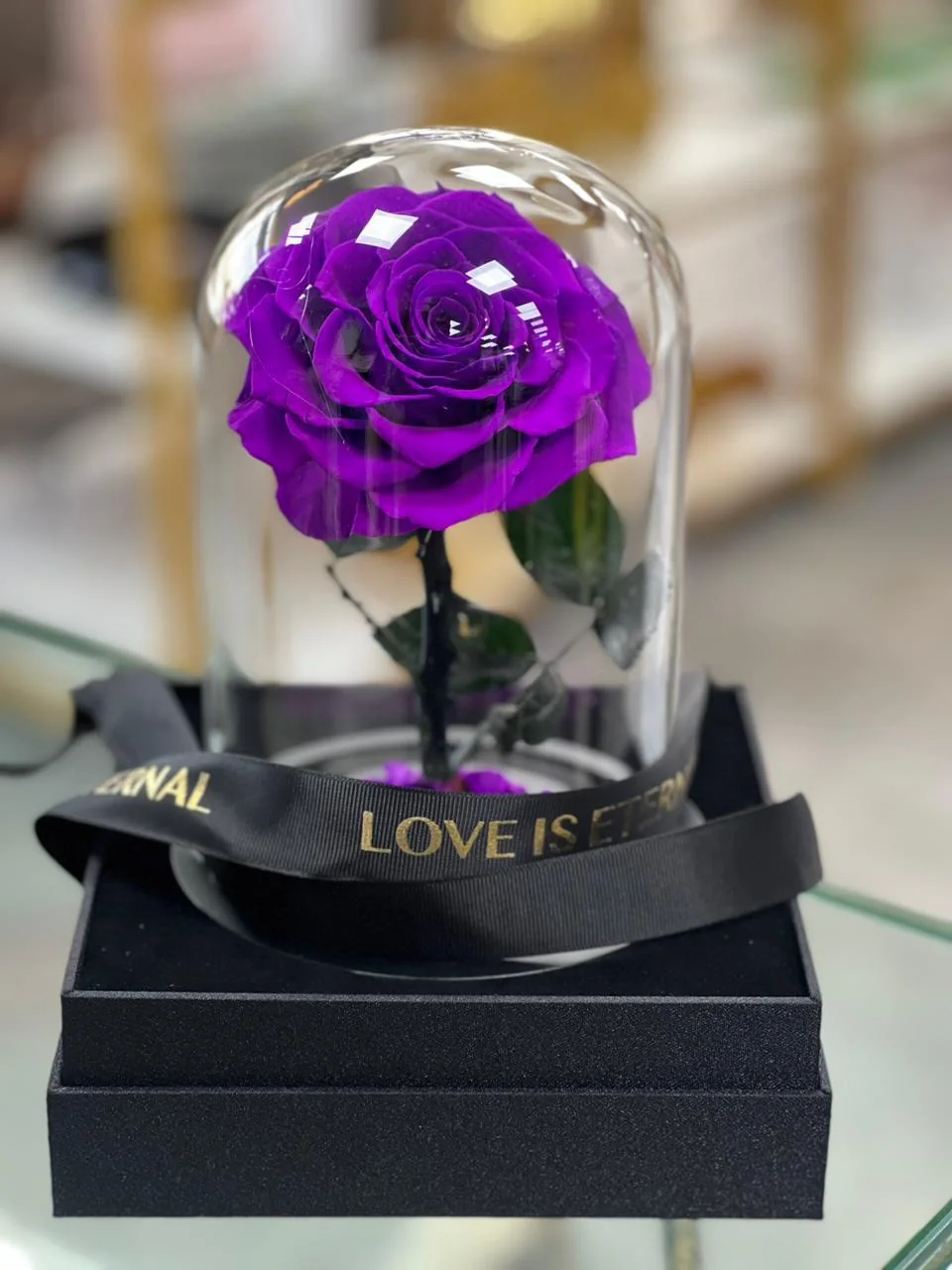 Purple infinite rose under a clear dome on a black gift box