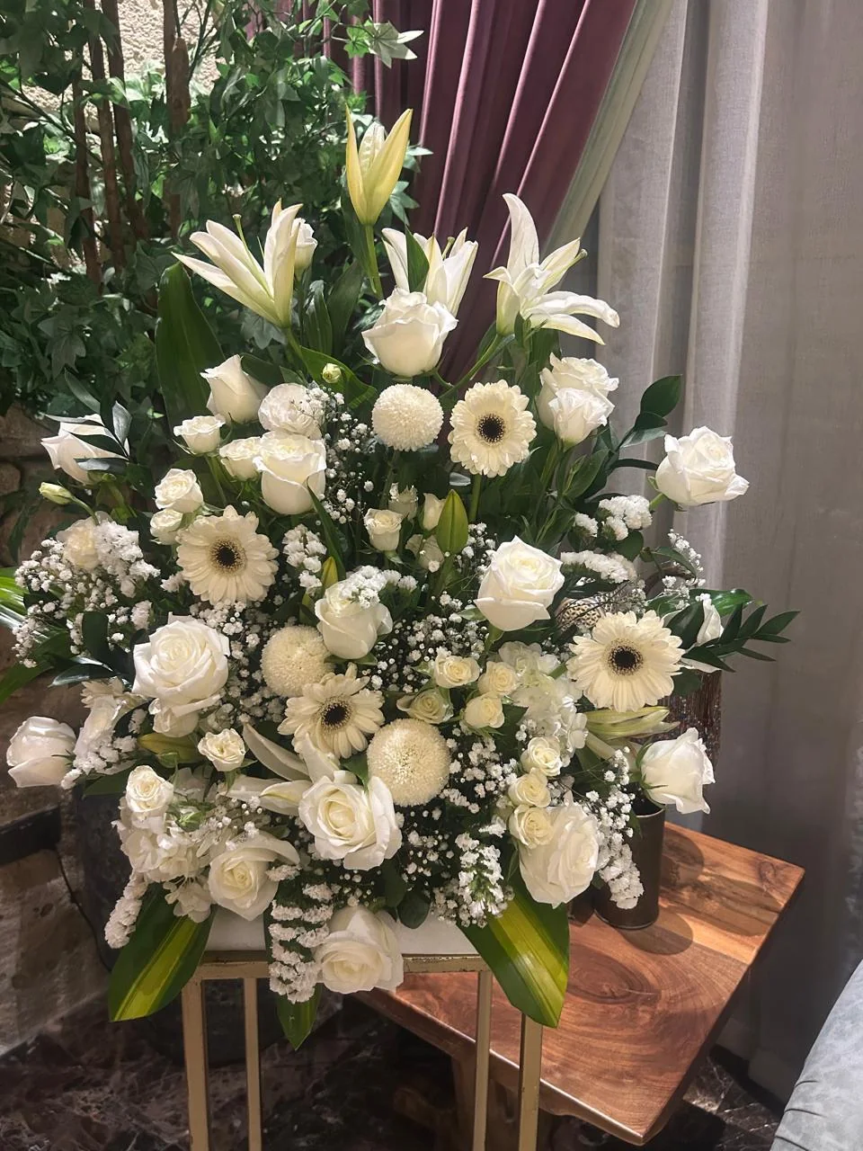 Tall royal wedding arrangement of white roses, lilies and daisies