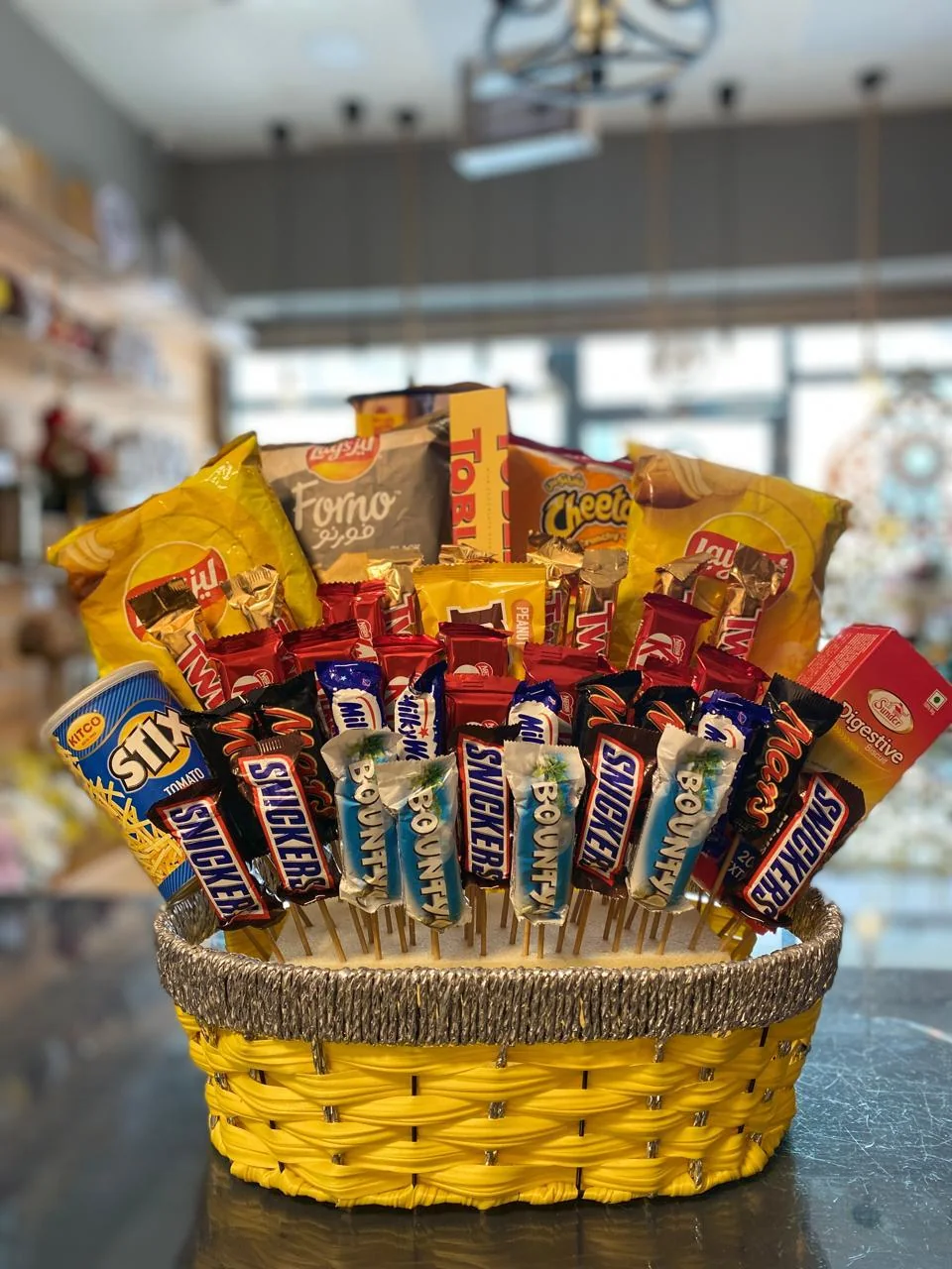 Yellow woven snack gift basket filled with assorted chocolate bars