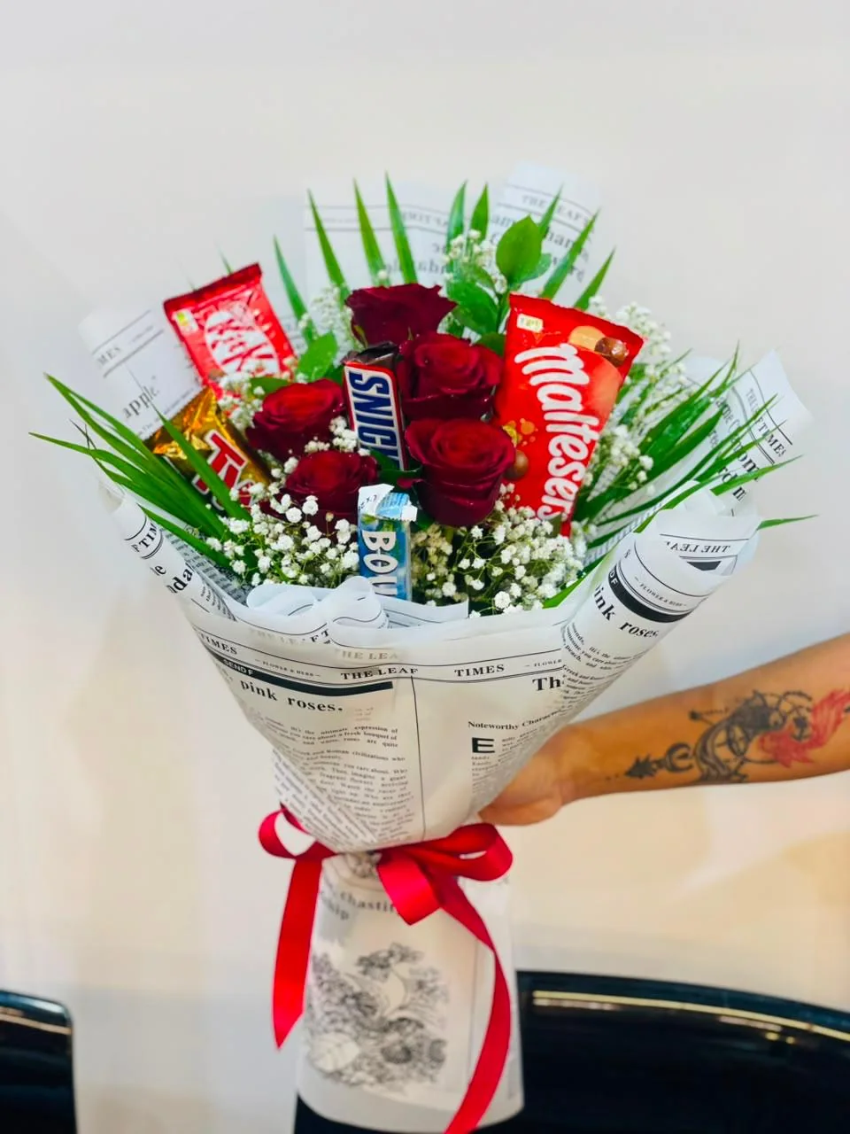 Snack bouquet with assorted chocolate bars, greenery and newspaper wrapping
