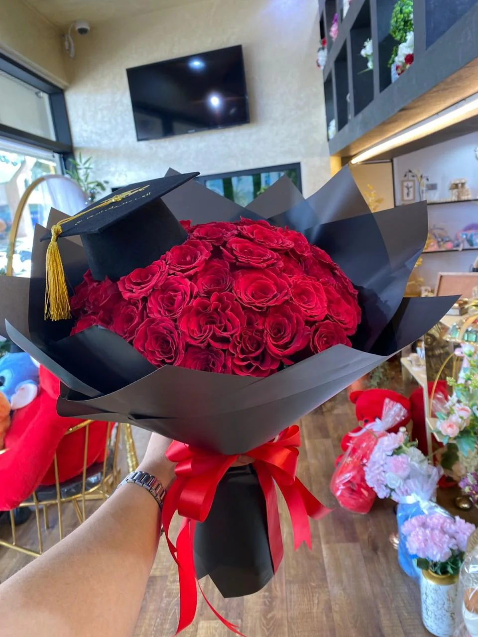 Large red rose graduation bouquet with black wrapping and a graduation cap