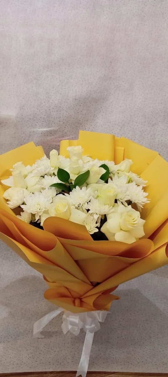 Sunshine bouquet of white daisies and greenery in yellow wrapping