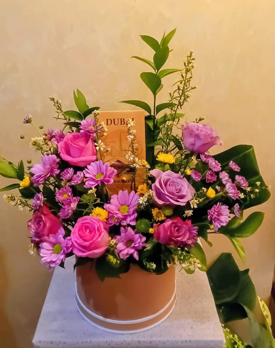 Bronze flower box with purple and pink blooms and Dubai chocolate bars