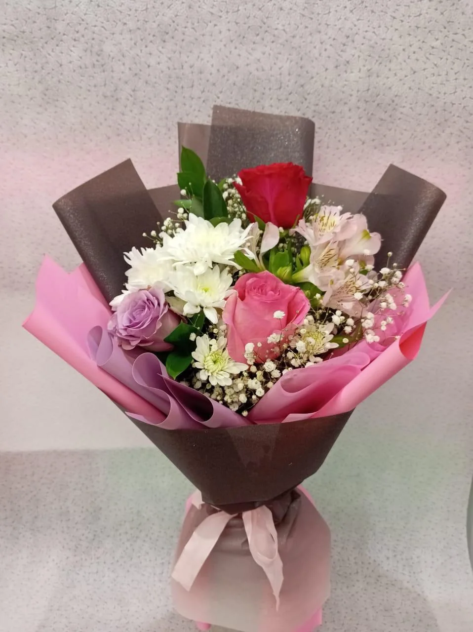 Sweet garden bouquet with pink, white and burgundy blooms in blush-grey wrapping