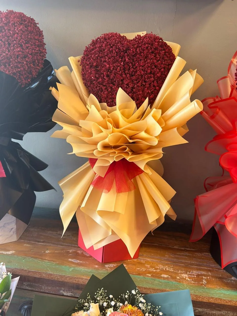 Valentine heart bouquet of red dried flowers with sculpted gold wrapping