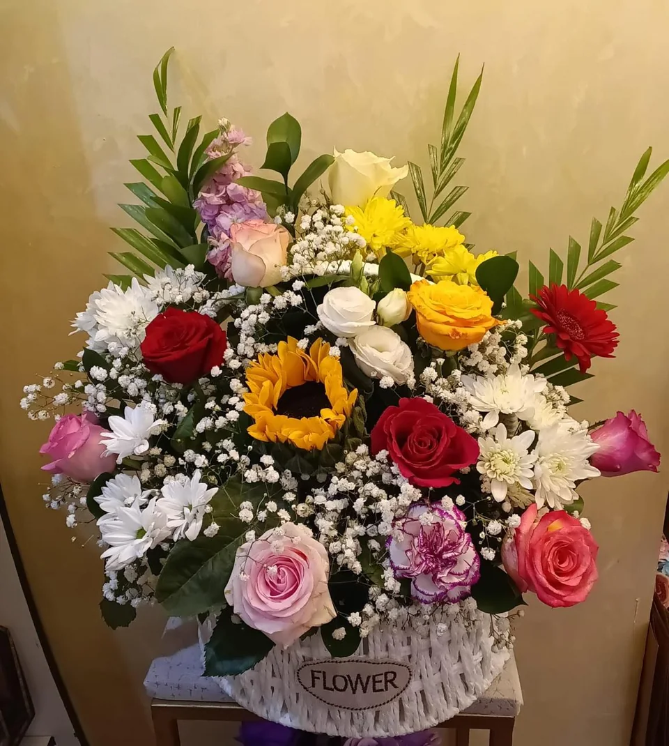 Vibrant mixed flower basket with sunflowers and red, pink and white blooms