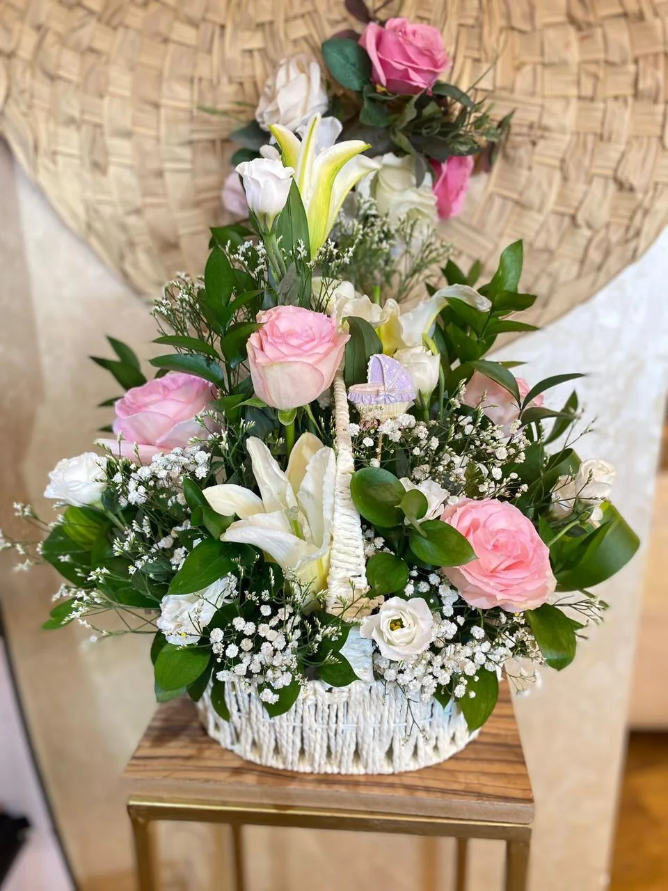 Welcome-baby flower basket with pink and white roses, lilies and a baby-carriage ornament