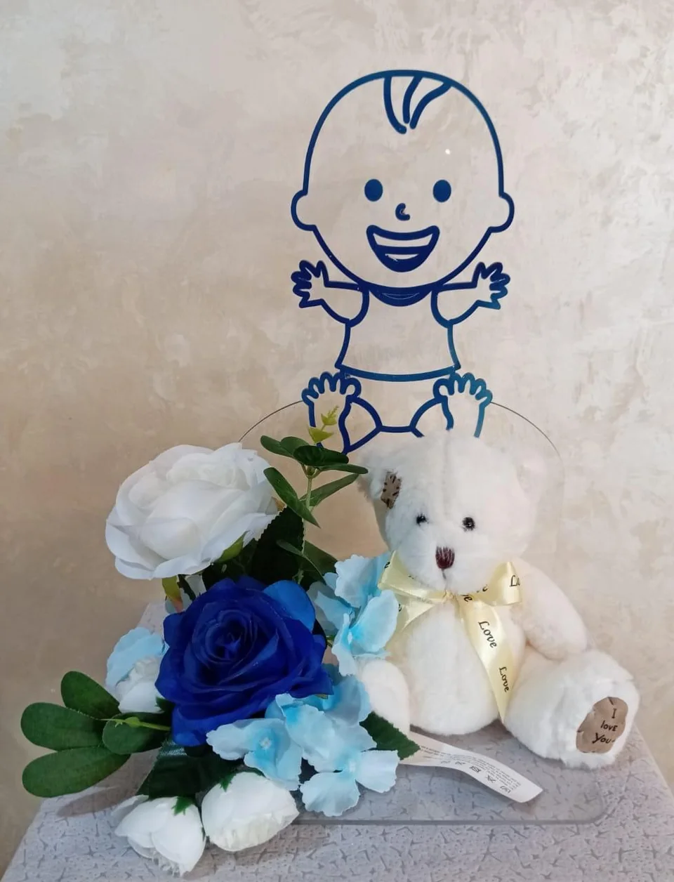 Welcome-baby-boy stand with blue baby graphic, blue-white flowers and a teddy bear