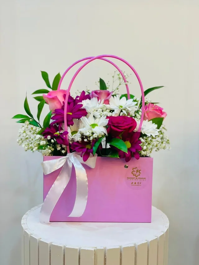 White and pink handled flower bag with pink roses and white blooms