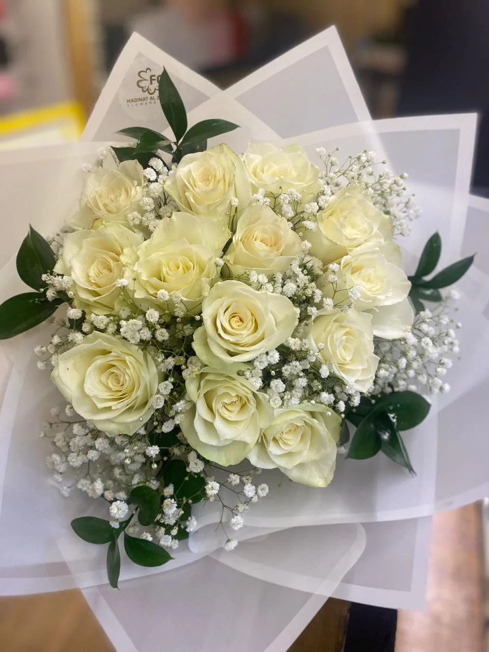 White rose bouquet with baby's breath and translucent white wrapping