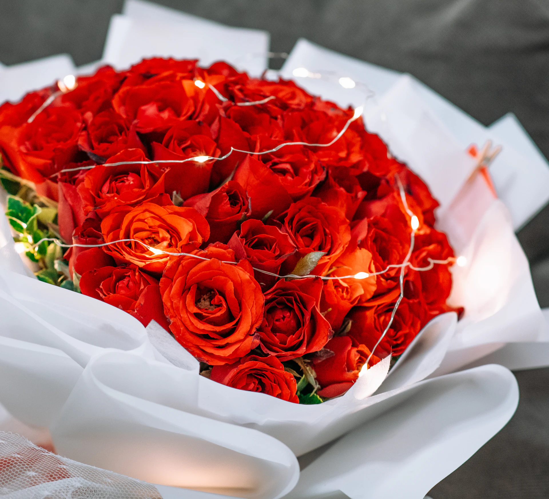 Red roses wrapped in clean white paper